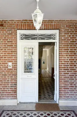 a white door with a window and a brick wall at Stou Savvide - Pera Pedi Stone Manor in Perapedhi
