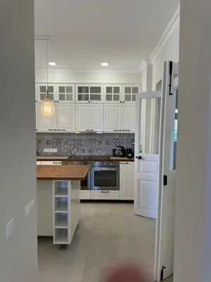 a kitchen with white cabinets and a stove top oven at Stou Savvide - Pera Pedi Stone Manor in Perapedhi