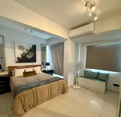 a bedroom with a large bed and a large window at Atalanta rooms in Larnaka
