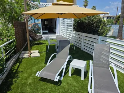 a patio with a table and chairs and an umbrella at Protaras Ayios Elias Maisonette in Protaras
