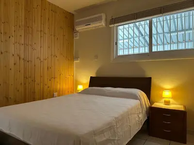 a bedroom with a bed and a window and two lamps at White House with Garden and BBQ in Strovolos in Nicosia