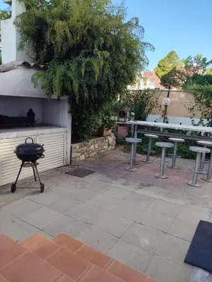 a grill and picnic tables in a yard at White House with Garden and BBQ in Strovolos in Nicosia