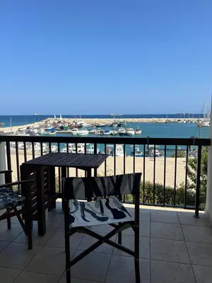a table and chairs on a balcony with a view of the beach at Zygi Beachfront Retreat! in Zygi