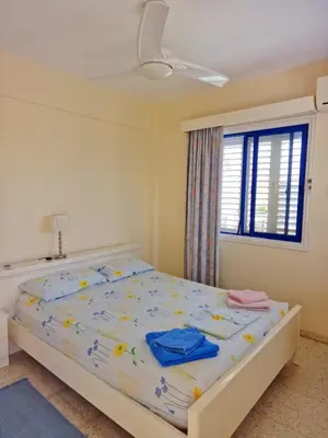 a bedroom with a bed with a blue shirt on it at Quiet Top Floor One Bedroom Apartment in Pyla Near Beach in Voroklini