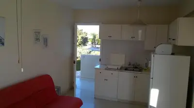a kitchen with a red couch and a refrigerator at Quiet Top Floor One Bedroom Apartment in Pyla Near Beach in Voroklini