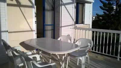 a white table and chairs on a balcony at Quiet Top Floor One Bedroom Apartment in Pyla Near Beach in Voroklini