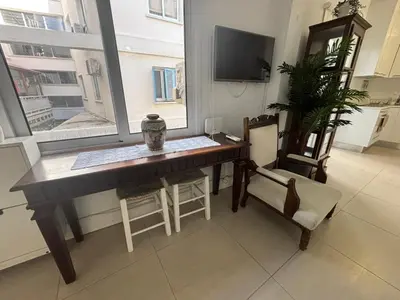 a living room with a desk and a window at Modern 2BR Apartment 70m from Finikoudes beach in Larnaka