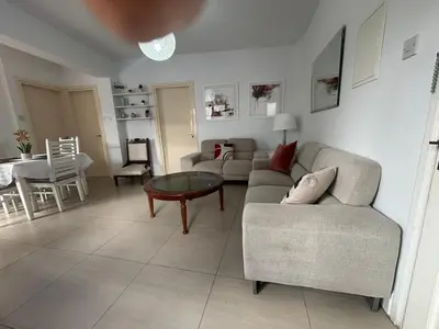 a living room with a couch and a table at Modern 2BR Apartment 70m from Finikoudes beach in Larnaka