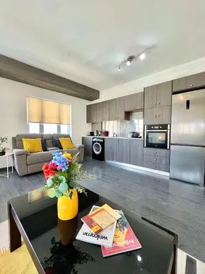 a kitchen and living room with a table in a living room at Millenia Apartment in Nicosia