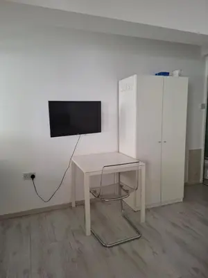 a white desk with a television on a wall at Comfortable Ground Floor Studio in Limassol in Limassol