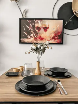 a wooden table with black plates and wine glasses at Boho Studio mit Meerblick in Boğaz