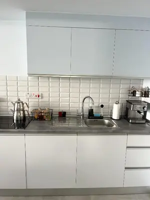 a kitchen with white cabinets and a sink at Boho Studio mit Meerblick in Boğaz