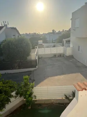 a view of a parking lot with a white fence at Protaras entire house in Protaras