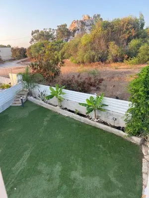 a backyard with green grass and a white fence at Protaras entire house in Protaras