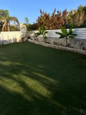 a yard with green grass and a white fence at Protaras entire house in Protaras