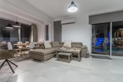 a living room with a couch and a table at Black Swan Villa in Pervolia