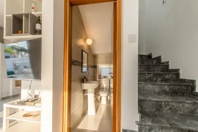 a bathroom with a toilet and a staircase at Black Swan Villa in Pervolia