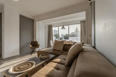 a living room with a brown couch and a window at Black Swan Villa in Pervolia