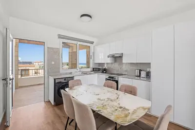 a kitchen and dining room with a table and chairs at Nautical Club Penthouse Apartments in Larnaka