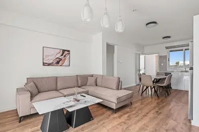 a living room with a couch and a table at Nautical Club Penthouse Apartments in Larnaka