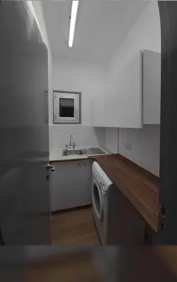 a kitchen with a sink and a washing machine at A separate room with a shared bathroom and 50 meters from the sea in Zygi
