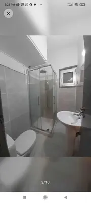 a bathroom with a shower and a toilet and a sink at A separate room with a shared bathroom and 50 meters from the sea in Zygi