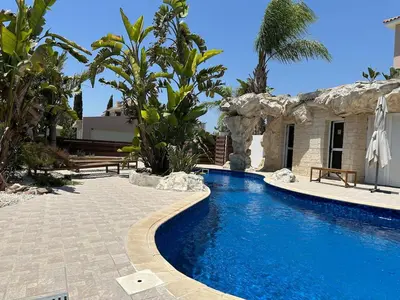 a swimming pool in front of a house at Majestic Gardens 10 minutes from Larnaka Airport in Tersephanou