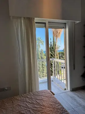 a bedroom with a bed and a sliding glass door at Уютные Апартаменты с Балконом in Limassol