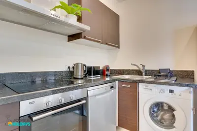 a kitchen with a washing machine and a sink at Dios Ponte 102 Beachfront in Larnaka