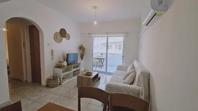 a living room with a couch and a television at STAY Miracle Apartment in Larnaka