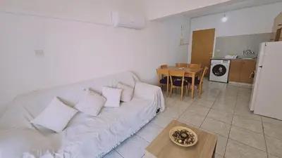 a living room with a white couch and a table at STAY Miracle Apartment in Larnaka