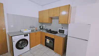 a kitchen with a washing machine and a refrigerator at STAY Miracle Apartment in Larnaka