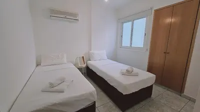 two beds in a small room with towels on them at STAY Miracle Apartment in Larnaka
