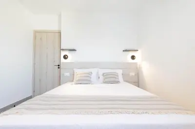 a bedroom with a white bed with two pillows at Napa Heights in Ayia Napa