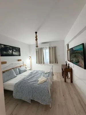 a white bedroom with a bed and a table at Sunny Escape, Protaras, Cyprus in Protaras