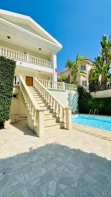 a house with a staircase next to a swimming pool at Alkeou Holiday Home in Limassol
