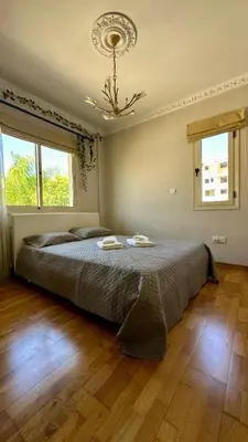 a bedroom with a large bed with a chandelier at Alkeou Holiday Home in Limassol