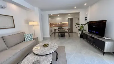 a living room with a couch and a table at Kantara Garden Apt by TrulyCyprus in Limassol