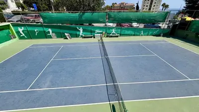 a tennis court with a net on top of it at Kantara Garden Apt by TrulyCyprus in Limassol