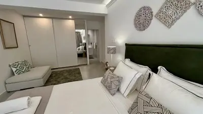 a bedroom with a large white bed and a couch at Kantara Garden Apt by TrulyCyprus in Limassol