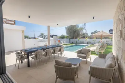 a patio with a table and chairs and a pool at Ayia Napa Orea Villa OR2 in Ayia Napa
