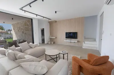 a living room with a white couch and a tv at Ayia Napa Orea Villa OR2 in Ayia Napa