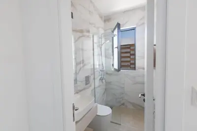 a white bathroom with a toilet and a sink at Ayia Napa Orea Villa OR2 in Ayia Napa
