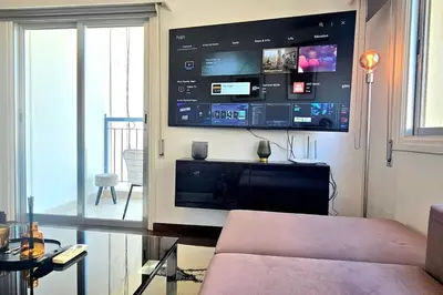 a living room with a large tv on the wall at Central Park Suave 2 Bed in Limassol