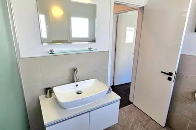 a bathroom with a white sink and a mirror at Central Park Suave 2 Bed in Limassol
