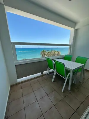 a room with a table and chairs and a large window at GARNET Beach Apartment in Voroklini