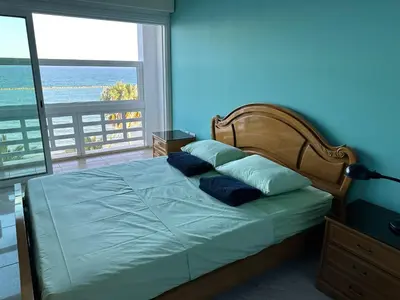 a bedroom with a bed with a view of the ocean at GARNET Beach Apartment in Voroklini
