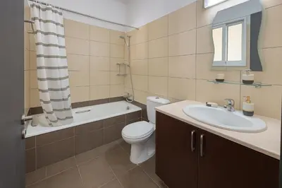 a bathroom with a toilet and a sink and a tub at Sunflight Apt 01B One Bedroom Apt in Larnaka