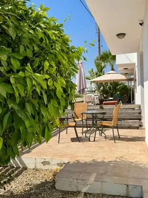 a patio with a table and chairs and an umbrella at Sunflight Apt 01B One Bedroom Apt in Larnaka