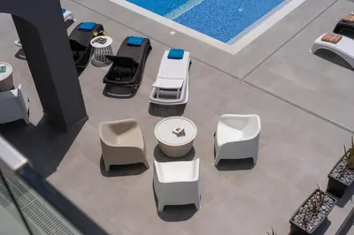 a group of chairs and tables and a pool at Exclusive 7-Bdr Villa with Panoramic Views & Saltwater swimming pool! in Ayia Napa